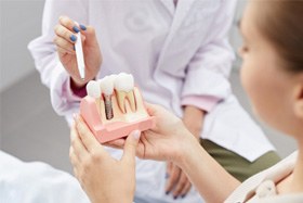 dentist explaining dental implant to patient 