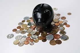 Black piggy bank and loose coins