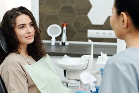 Woman in dental chair listening to dentist