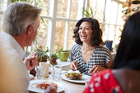 Woman smiling while eating lunch with friends