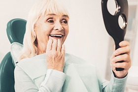 Woman admiring her new dental implants in Dallas