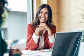 Woman with dental implants in Dallas, TX sitting and smiling