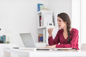 Woman with dental implants in Dallas, TX chewing on a pencil 