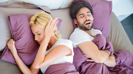 man snoring and wife covering ears