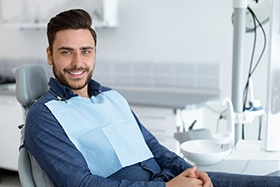 Man sitting in dental chair with hands folded