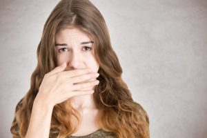 Woman covering her mouth.