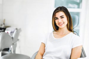 Woman with brown hair smiling in dental chair