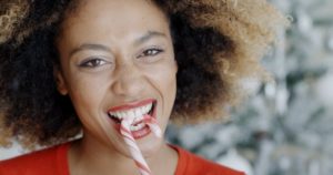 woman biting into a candy cane 