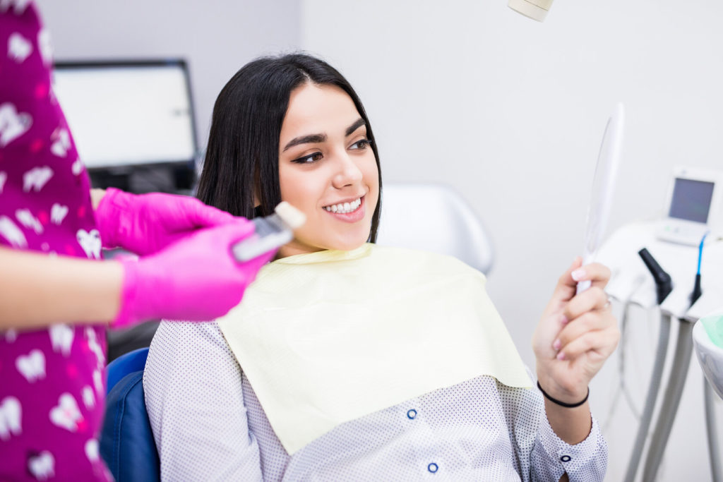 patient smiling after a dental emergency in Dallas