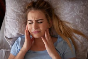 a person in bed suffering from a toothache