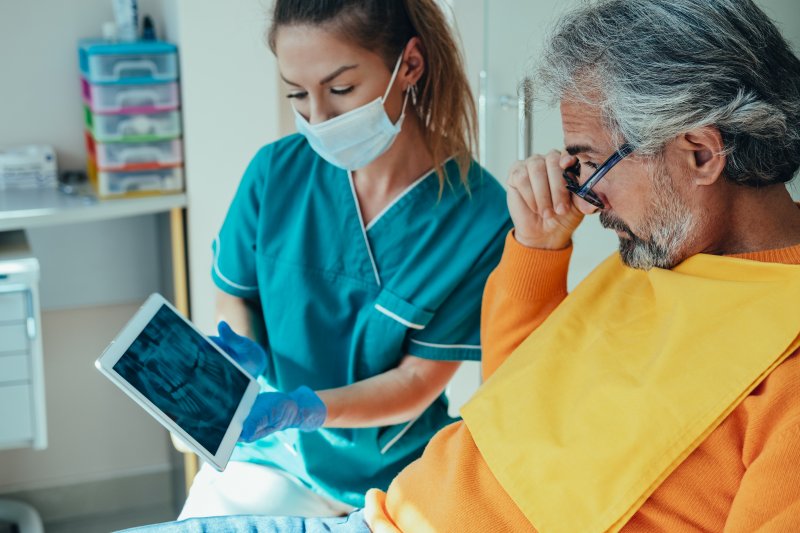 male patient talking to dentist about dental implants